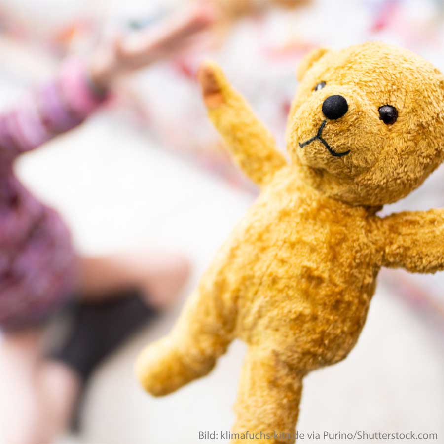 Ein Kind spielt mit einem Teddybären