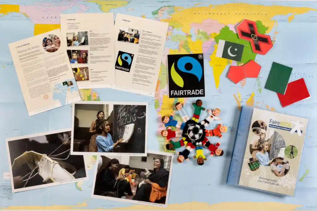 Der Inhalt des Bildungspaketes "Fairer Fussball" ausgebreitet auf einer Weltkarte